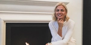 Η Χριστίνα Κοντοβά με λευκό σύνολο μπροστά στο τζάκι