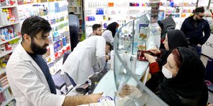 Φαρμακοποιός συζητά με πελάτες στην Τεχεράνη