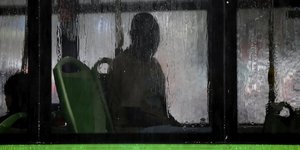 Άνδρας σε λεωφορείο στο Μιλάνο, σε βροχερή ημέρα