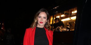 Η Ανίτα Μπραντ με κόκκινο κοστούμι και κόκκινες γόβες