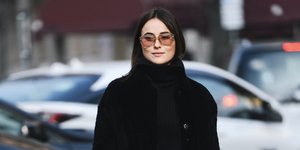 γυναίκα με μαύρο παλτό και γυαλιά στην εβδομάδα μόδας