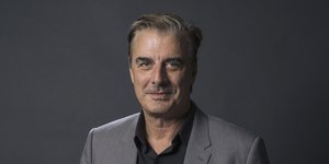 Ο Κρις Νορθ με γκρι σακάκι και μαύρο πουκάμισο