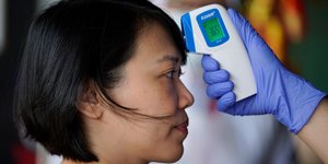 Ιατρικό προσωπικό μετρά την θερμοκρασία σε ασθενή