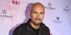 Ο Δημήτρης Σκουλός με γκρι παντελόνι και μαύρο τοπ