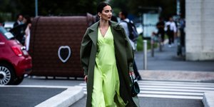 γυναίκα με πράσινο φόρεμα περπατά στο δρόμο