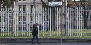 Γυναίκα περπατά σε δρόμο της Ιταλίας, φορώντας μάσκα