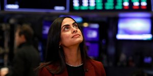 Γυναίκα κοιτάζει τις οθόνες στο χρηματιστήριο