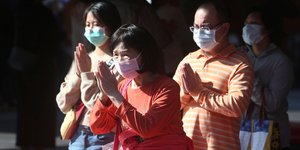 Γυναίκα με μάσκα προσεύχεται