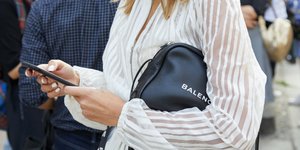 Γυναίκα με μαύρη τσάντα και λευκό μανικιούρ 