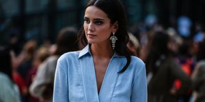 Γυναίκα με γαλάζιο τοπ και σκουλαρίκια στην Εβδομάδα Μόδας