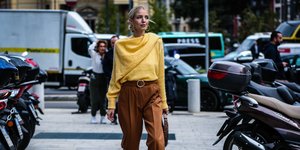 Γυναίκα με κίτρινο τοπ και καφέ παντελόνι 