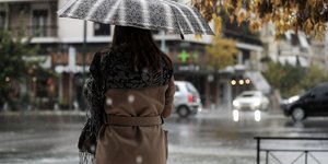 Γυναίκα κρατάει ομπρέλα στην βροχή