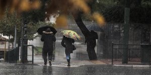 Ανθρωποι με ομπρέλες στον δρόμο