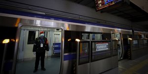 Άνδρας της ασφάλειας με μάσκα πρόληψης από τον κορωνοϊό στο μετρό της Κίνας