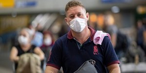 Άνδρας με μάσκα λόγω κορωνοϊού σε αεροδρόμιο