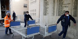 Ιατρικό προσωπικό μεταφέρει έξτρα κρεβάτια σε νοσοκομείο της βόρειας Ιταλίας