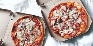 Δύο κουτιά με πίτσα πάνω σε λευκό φόντο
