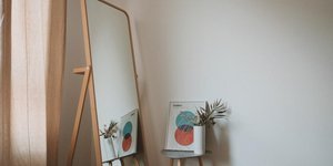 Mεγάλος καθρέπτης, τραπεζάκι, φυτό, κουρτίνα σε κρεβατοκάμαρα