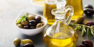 Μπουκάλι με λάδι και ελιές σε μπολ