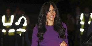 Η Μέγκαν Μαρκλ με μωβ φόρεμα και κυματιστά μαλλιά