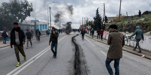 Μετανάστες περπατούν σε δρόμο μετά από επεισόδια