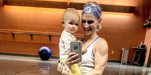 Μητέρα bodybuilder κρατάει μωρό στην αγκαλιά της 