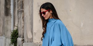 Γυναίκα με μπλε μπλούζα και μπεζ παντελόνι