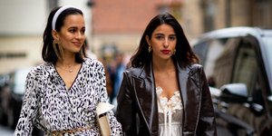 γυναίκες με φορέματα και πανωφόρια περπατούν στην εβδομάδα μόδας