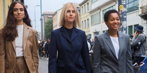 Τρεις γυναίκες με κοστούμια περπατούν στο δρόμο