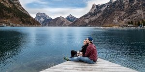 Ζευγάρι αγκαλιά με φόντο βουνά και λίμνη