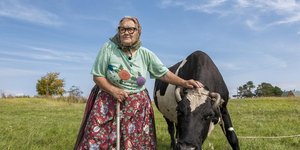ηλικιωμένη γυναίκα με γυαλιά ακουμπά ταύρο
