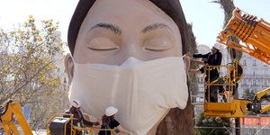 Εργάτες στη Βαλένθια τοποθετούν μάσκα προστασίας από τον κορωνοϊό σε άγαλμα