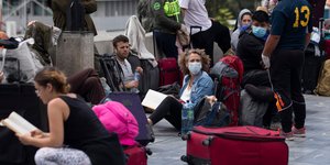 Επιβάτες με βαλίτσες περιμένουν