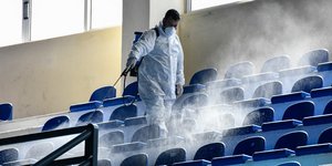 Άνδρας απολυμαίνει κερκίδες ως μέτρα πρόληψης κατά του κορωνοϊού