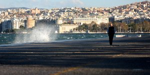 Ανδρας περπατάει δίπλα σε προβλήτα με κύμα