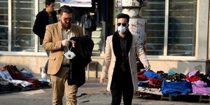 Ανδρες περπατούν με ιατρικές μάσκες