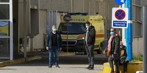 Ανδρες με μάσκες έξω από νοσοκομείο