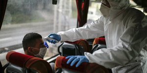 Τούρκοι υπάλληλοι ελέγχουν τη θερμοκρασία πολιτών σε λεωφορείο, εν μέσω πανδημίας κορωνοϊού