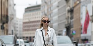 Γυναίκα με λευκό παλτό, μαύρα γυαλιά και καφέ μπότες 