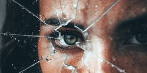 Γυναίκα πίσω από σπασμένο τζάμι