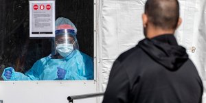 Γιατρός σε προστατευτικό τζάμι