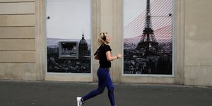 Γυναίκα τρέχει σε πεζοδρόμιο του Παρισιού