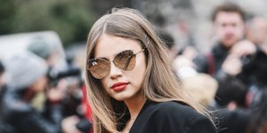 Γυναίκα με μακριά μαλλιά, γυαλιά και κόκκινο κραγιόν στην Εβδομάδα Μόδας 