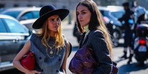 Γυναίκες με σακάκι και καπέλο συζητούν στην εβδομάδα μόδας