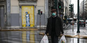 Ηλικιωμένος με ψώνια και μάσκα ενάντια στον κορωνοϊό στην άδεια Αθήνα