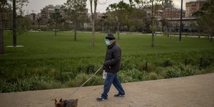 Ηλικιωμένος με μάσκα βγάζει βόλτα τον σκύλο του στην Ισπανία