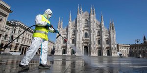 Ενας εργάτης απολυμαίνει την πλατεία Ντουόμο στο Μιλάνο