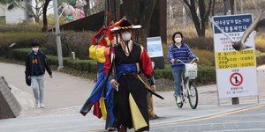 Κορεάτης με μάσκα και παραδοσιακή ενδυμασία