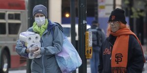 Κορωνοϊός γυναίκα με μάσκα αγοράζει χαρτί υγείας