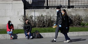 Ζευγάρι με μάσκες περπατούν στον δρομο